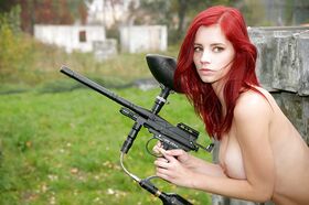 Stunning teen redhead Piper posing naked with a paintball gun