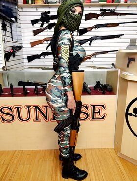 Camouflaged chick with rifle in hand lets her big natural breasts loose