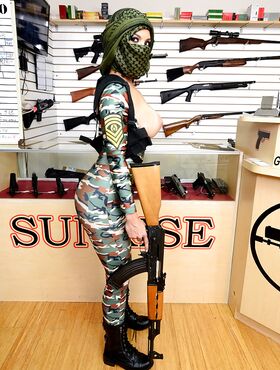 Camouflaged chick with rifle in hand lets her big natural breasts loose