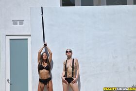 Dani Daniels and Lizz Tayler play lezdom games outside by a pool