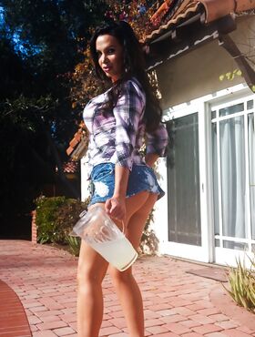 Buxom MILF Nikki Benz posing topless outdoors in denim shorts