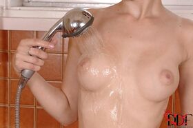 Brunette teen Timea Bela undresses before masturbating in tub with showerhead