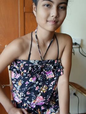 Petite Asian teen Pauw takes off her gown and flaunts her tits and hairy kitty