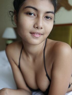 Petite Asian teen Pauw takes off her gown and flaunts her tits and hairy kitty