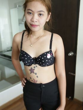 Petite Thai girl Mint strips off her clothes and shows her tiny hairy pussy