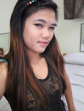 Young Filipina girl with a saucy look stands naked after undressing