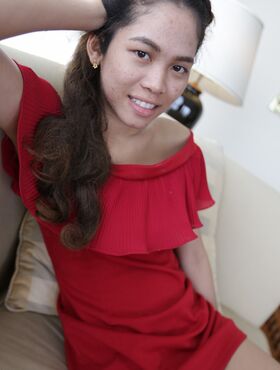 Cute first timer from Thailand poses in her red dress prior to modeling gig