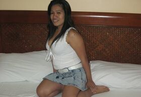 Filipina female exposes her huge all natural tits on a bed inside a motel room