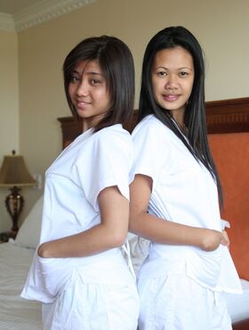 Lusty filipina nurses Joanna and Joy pose on the bed in their white uniforms