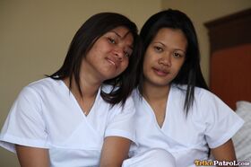 Lusty filipina nurses Joanna and Joy pose on the bed in their white uniforms