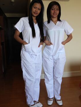 Lusty filipina nurses Joanna and Joy pose on the bed in their white uniforms