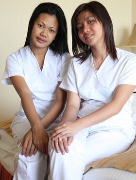 Lusty filipina nurses Joanna and Joy pose on the bed in their white uniforms