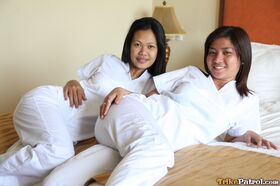 Lusty filipina nurses Joanna and Joy pose on the bed in their white uniforms