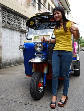 Female Tuk Tuk driver and a Farang ham it up for the camera in a back alley