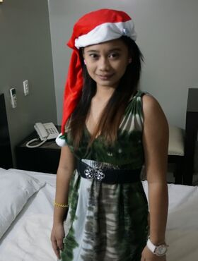 Cute Filipina teen gives a blowjob attired in a Santa Clause cap