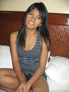 Cute Filipina girl strips to a black strapless bra and thong on a bed
