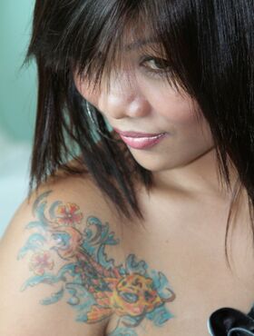 Tattooed Filipina girl dons white stockings while making her nude debut
