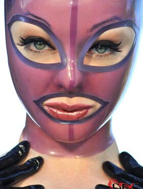 Latex Lucy frees her big tits and twat from lingerie in a rubber mask