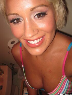 Short haired blonde Tristan Taylor undresses on bed to appease her boyfriend