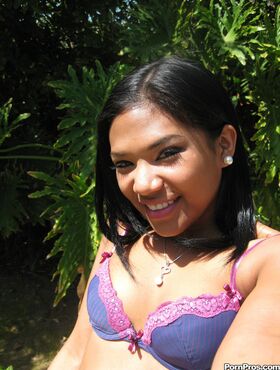 Smiling Latina babe Emy Reyes plays a clothed solo outdoors reveals hot curves