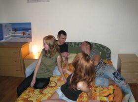 Horny teens experiment with swapping partners during a foursome on a bed