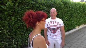 Mature woman with red hair penetrated by bald man on a grey sofa
