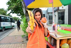 Beautiful Colombian fruit seller gestures provocatively with a banana