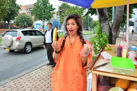 Beautiful Colombian fruit seller gestures provocatively with a banana
