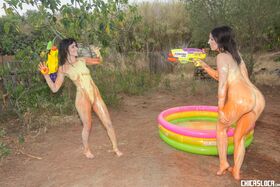 Latina lesbians Nerea Falco & Liz Rainbow have naked outdoor paintball fun