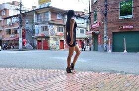 Long legged Colombian girl works free of a black dress for nude posing debut