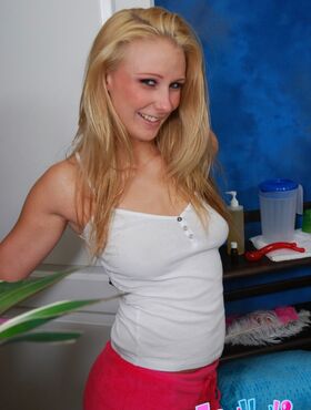 Smiley teenage blonde in pink shorts getting naked in the massage parlor