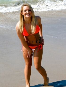 Sexy blonde with tattoos doffs bikini bra to feel the breeze on natural tits